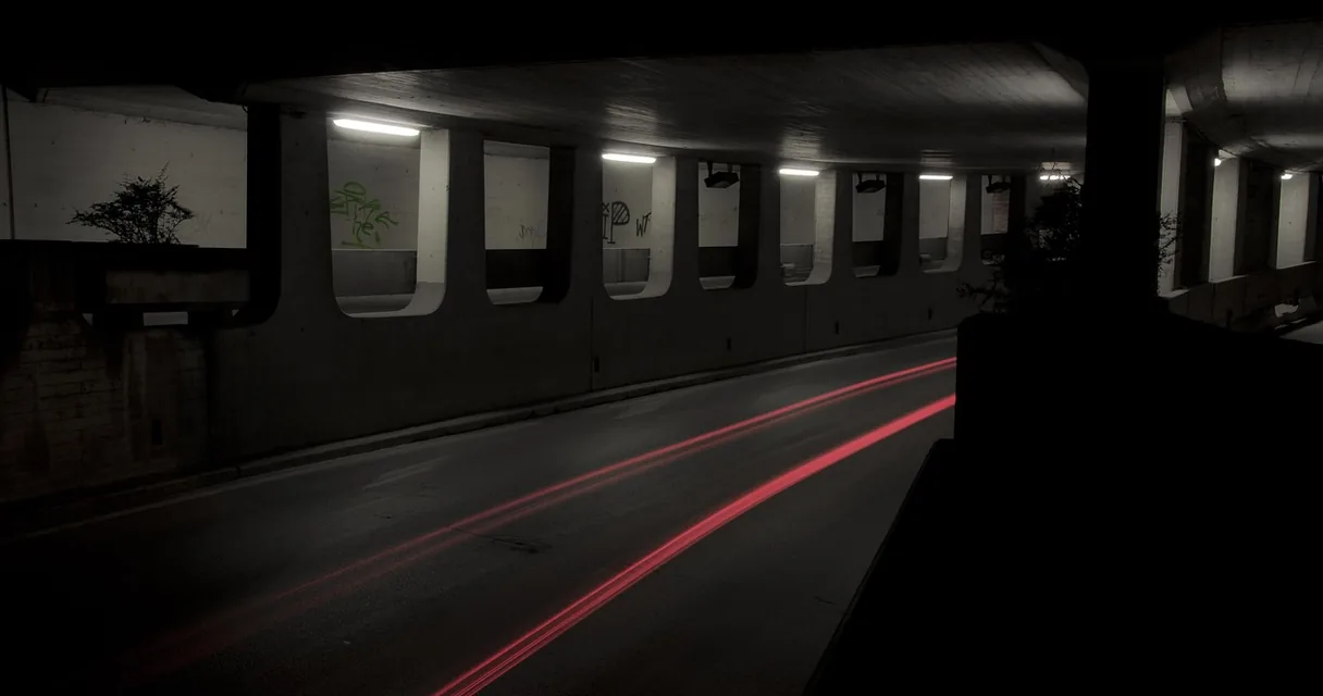 Túnel escuro com luzes e rastros vermelhos de carros, ilustrando a VPN com IPTV